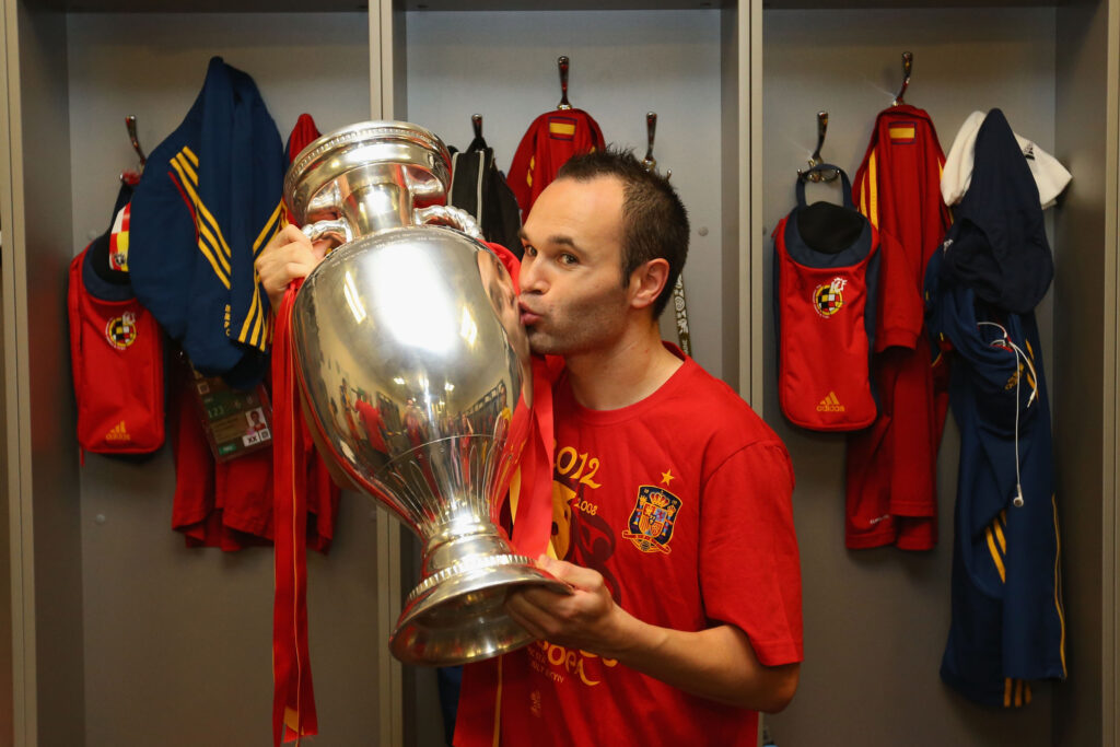 Andres Iniesta of Spain poses in the dressing room with the trophy following the UEFA EURO 2012 final match 