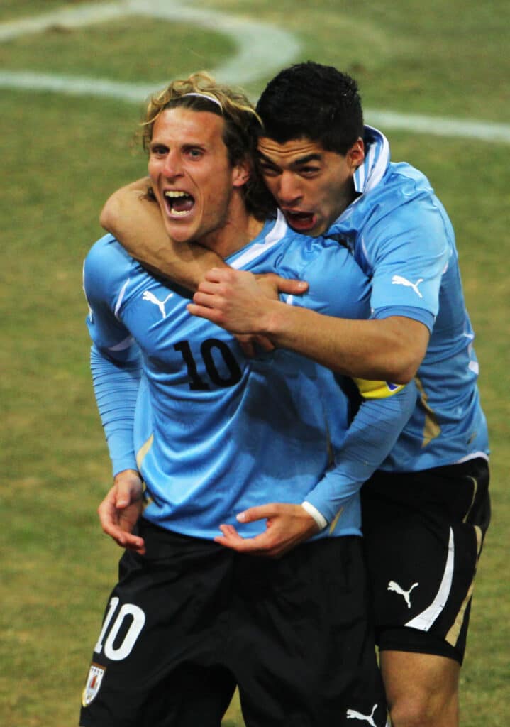  Diego Forlan of Uruguay celebrates scoring his side's first goal from a free kick with team mate Luis Suarez during the 2010 FIFA World Cup South Africa 