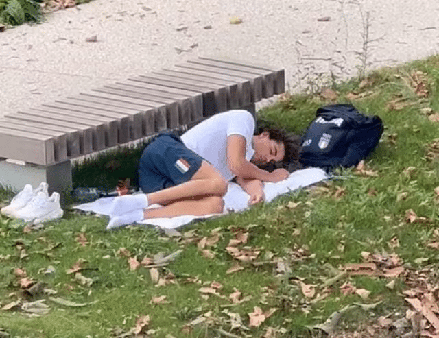 Thomas Ceccon dorme no gramado por conta do calor na vila olímpica